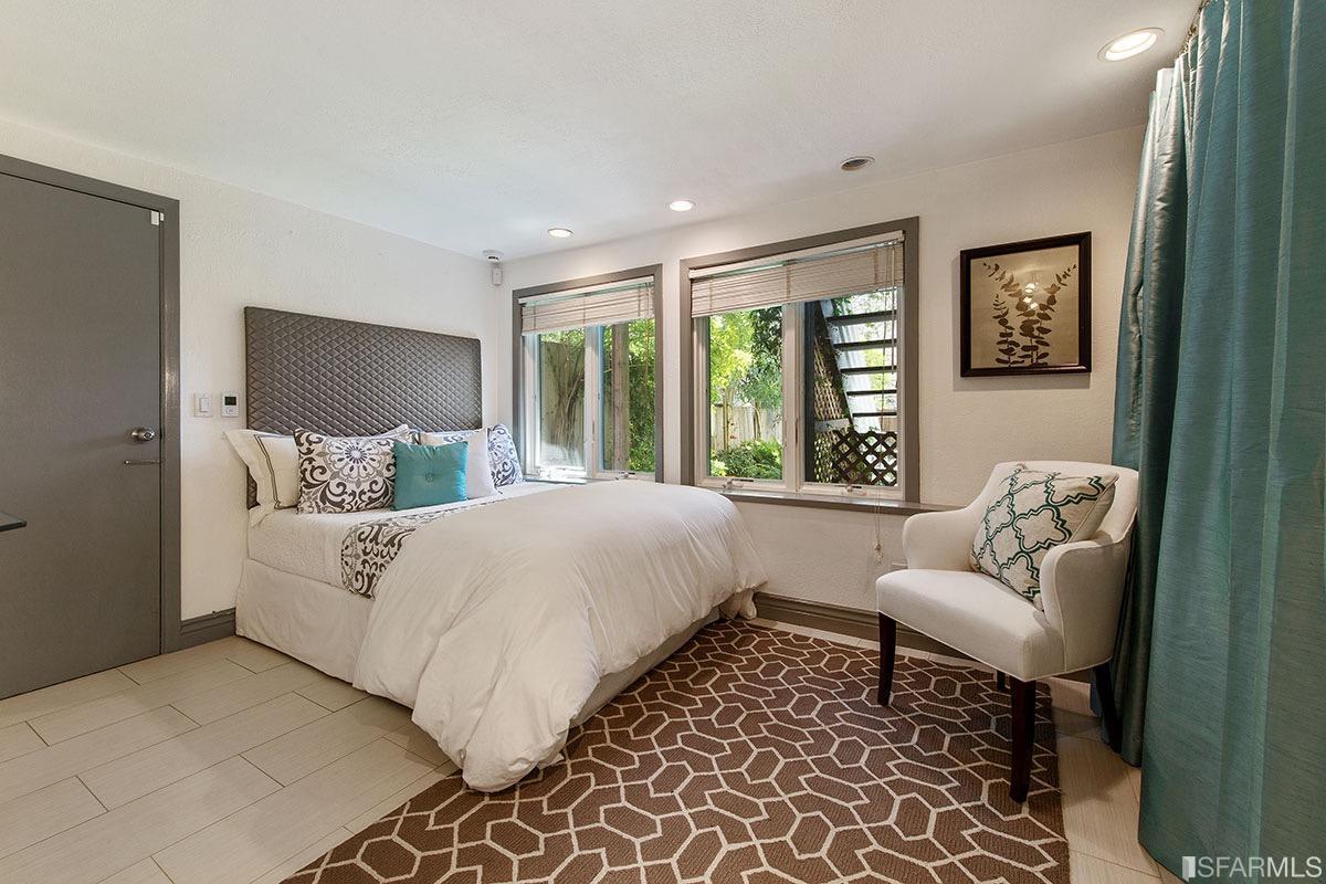 bedroom with window beneath stairs