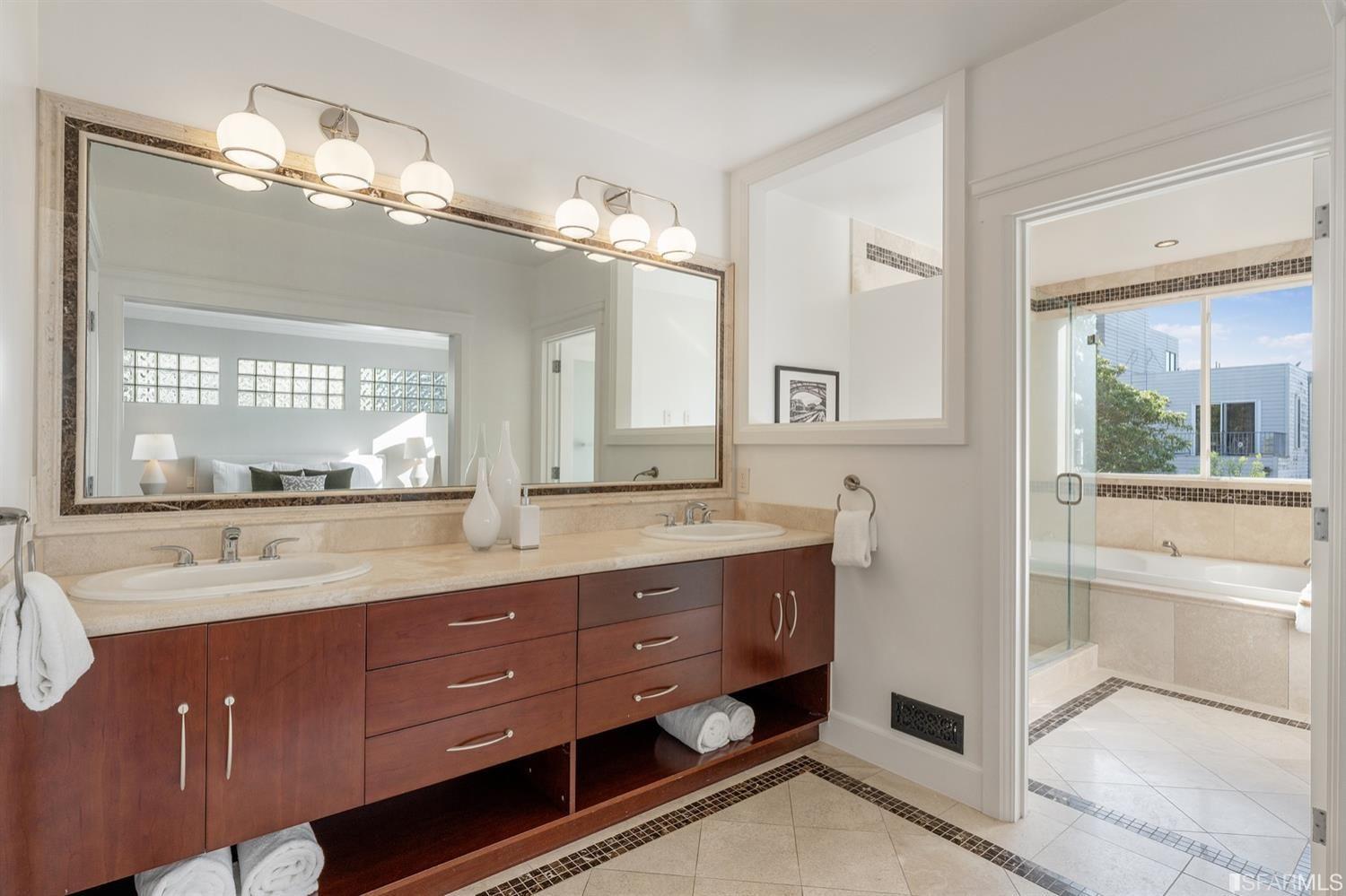 217-219 16th Avenue Master Bath with sinks, glass shower and bathtub.