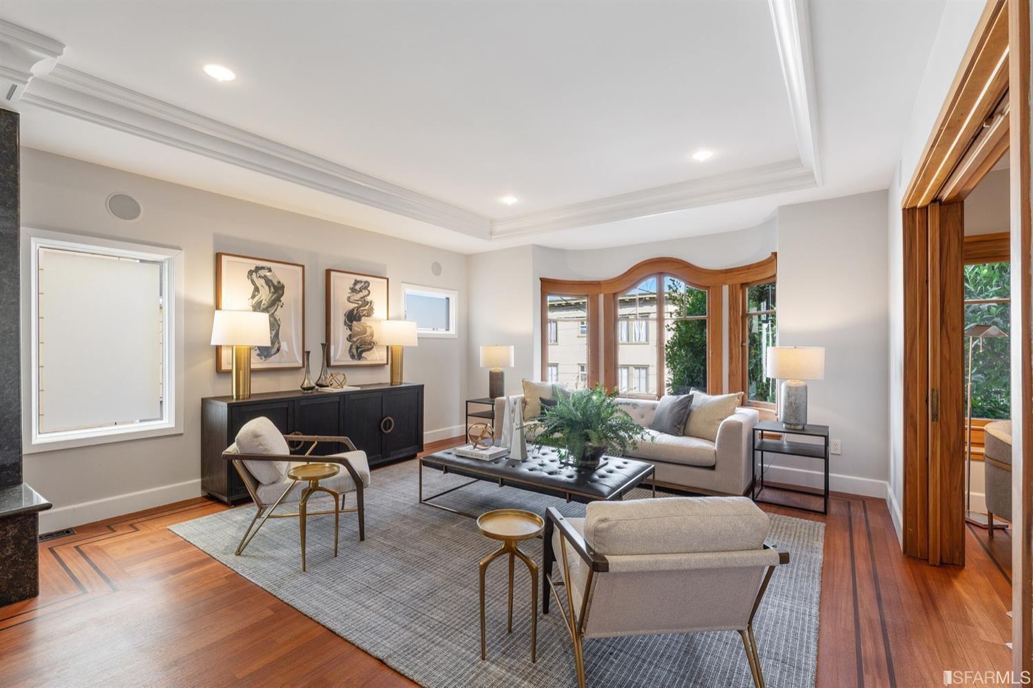 217-219 16th Avenue living room with modern chairs and sofa, black and white art, windows.